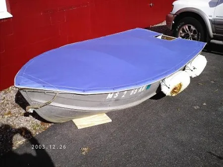 Blue fitted canvas cover on an aluminum boat