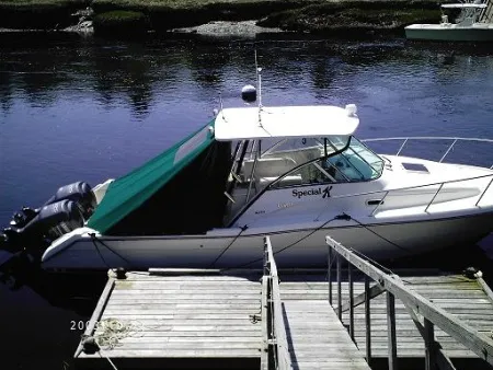 Green canvas top on a boat tied to a dock
